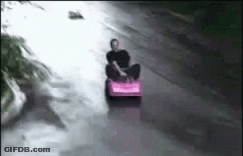 Man On Pink Sled Going Down River GIF