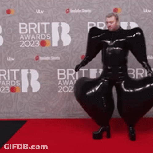 Man On Red Carpet In Front Of Brit Awards Wall GIF