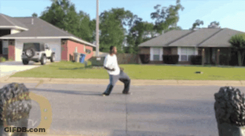 Man On Sidewalk In Front Of House With TV Logo GIF