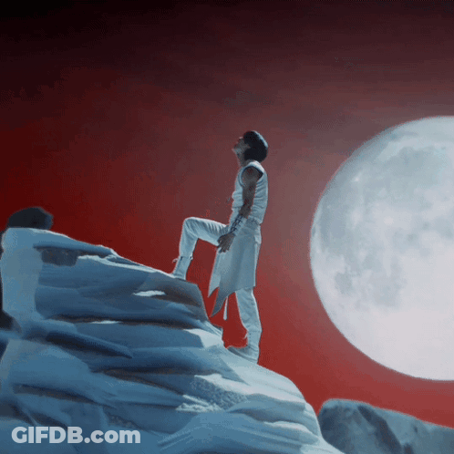 Man On Snowy Mountain With Full Moon GIF