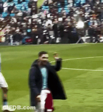Man On Soccer Field Holding Red Shirt GIF
