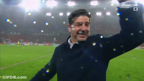 Man On Soccer Field With Arms In Air And BT Logo GIF