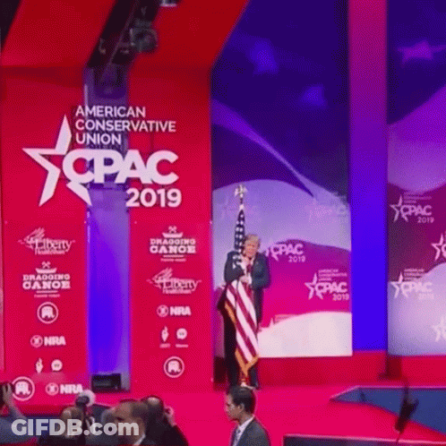 Man On Stage In Front Of American Conservative Union 2019 Sign GIF