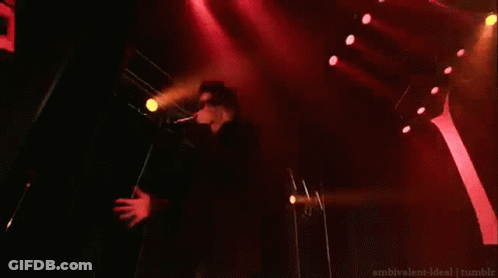 Man On Stage In Front Of Sign Saying M GIF