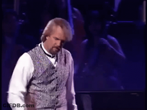 Man On Stage In Vest And Bow Tie GIF