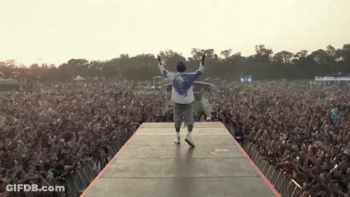 Man On Stage With Arms Outstretched Before Crowd GIF