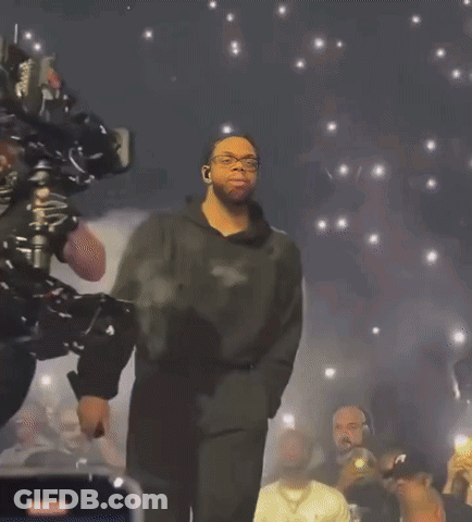 Man On Stage With Crowd Holding Phones GIF