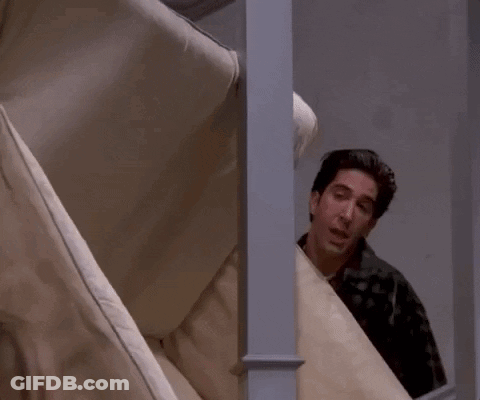 Man Peeking Behind Couch Says Pivot GIF