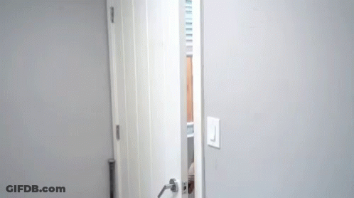 Man Peeking Out From Behind Door GIF