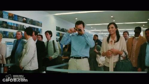 Man Photographing Woman In Crowded Area With Foreign Text GIF