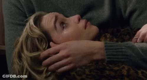 Man Placing Hand On Woman's Forehead On Couch GIF