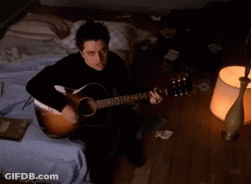Man Playing Acoustic Guitar With E On Neck GIF