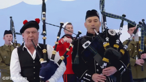 Man Playing Bagpipe With Scottish Badge GIF