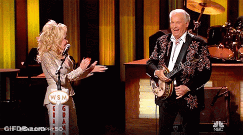 Man Playing Banjo Woman Sings Into Microphone WSM Sign GIF