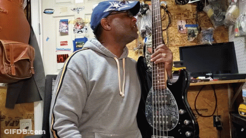 Man Playing Bass Guitar By Wall With Stihl Sticker GIF