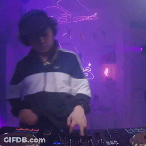 Man Playing DJ Set With Purple Background And Neon S Sign GIF