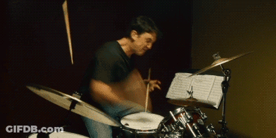 Man Playing Drum Set With Sheet Music GIF