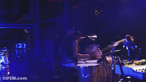 Man Playing Drums In Dark Room With Blue Light GIF