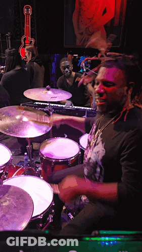 Man Playing Drums In Dark Room With Guitar GIF