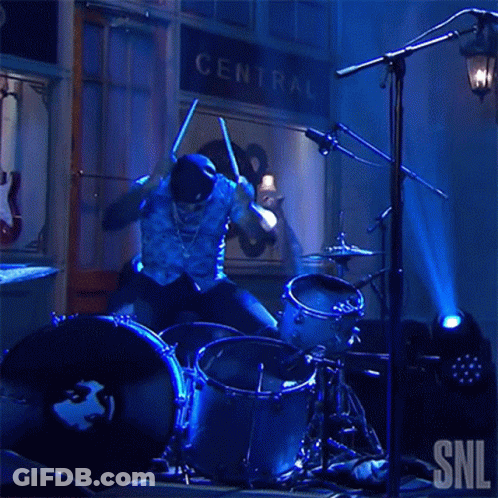 Man Playing Drums In Front Of Central Sign GIF