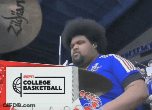 Man Playing Drums In Front Of ESPN College Basketball Ad GIF