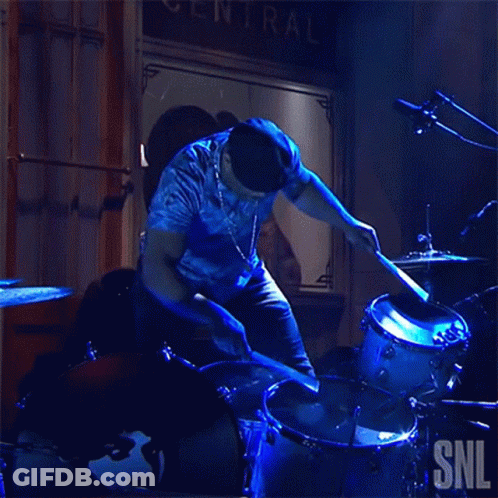 Man Playing Drums In Front Of SNL Sign GIF