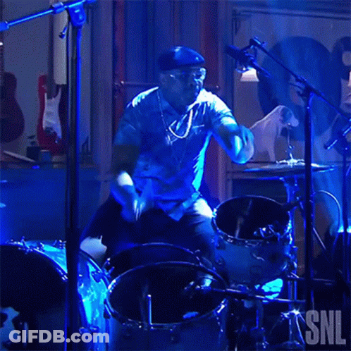 Man Playing Drums In Front Of SNL Sign GIF