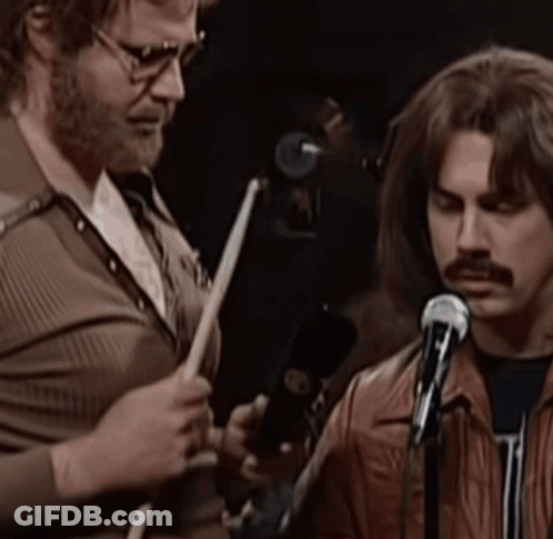 Man Playing Drums Next To Man With Mustache GIF