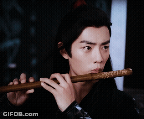 Man Playing Flute In Dark Room GIF