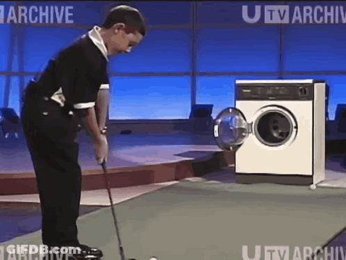 Man Playing Golf In Front Of Washing Machine GIF
