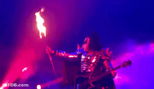 Man Playing Guitar Blowing Flames On Stage GIF