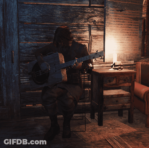 Man Playing Guitar In Dark Room With Lamp GIF