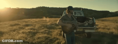 Man Playing Guitar In Field With Truck GIF