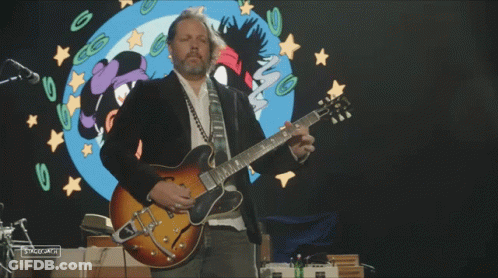 Man Playing Guitar In Front Of Cartoon Girl GIF