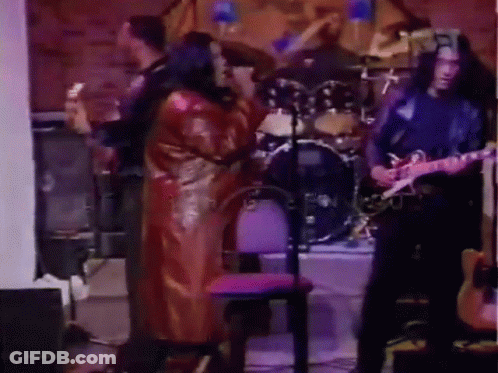 Man Playing Guitar In Front Of Drum Set With Woman Singing GIF