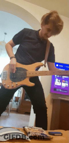 Man Playing Guitar In Front Of TV And M&Ms GIF