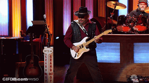 Man Playing Guitar In Front Of WSM Sign GIF