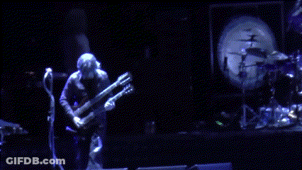 Man Playing Guitar On Stage With Drum Set GIF