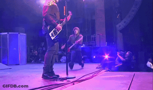 Man Playing Guitar On Stage With Purple Lights GIF