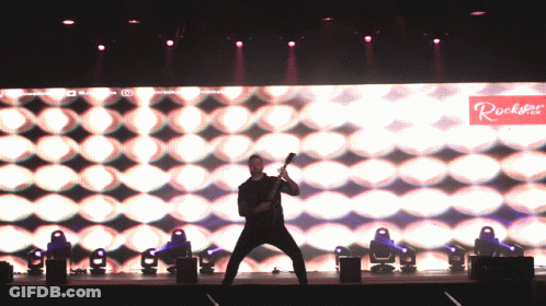 Man Playing Guitar On Stage With Rockstar Sign GIF