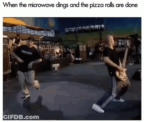 Man Playing Guitar While Another Runs On Stage GIF