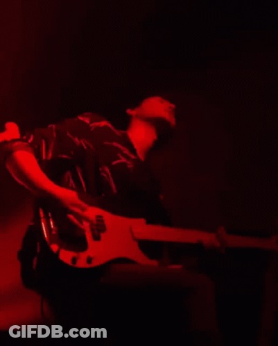 Man Playing Guitar With Headphones On Red Wall GIF