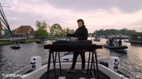Man Playing Music On Boat With Boats GIF