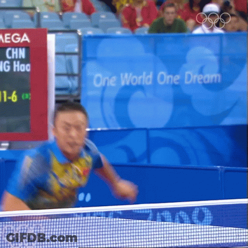 Man Playing Ping Pong In Front Of One World One Dream Sign GIF