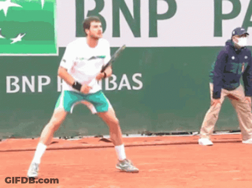 Man Playing Tennis In Front Of BNP Banner GIF