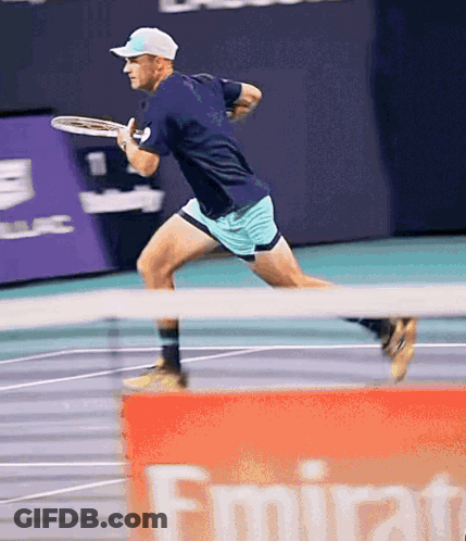 Man Playing Tennis In Front Of Emirates Banner GIF