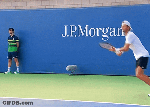 Man Playing Tennis In Front Of J.P. Morgan Sign GIF