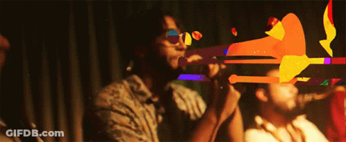 Man Playing Trumpet In Dark Room, Another Watches GIF