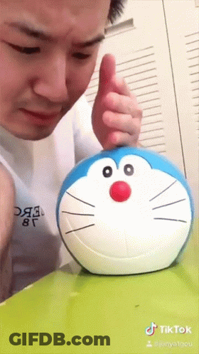 Man Playing With Stuffed Doraemon GIF