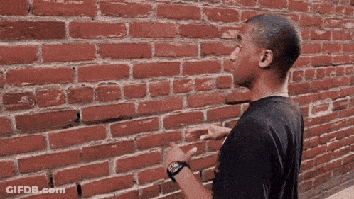 Man Pointing At Brick Wall GIF
